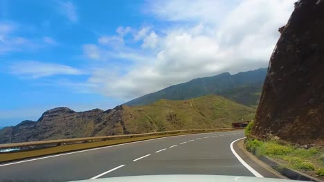 Idyllic-Drive-On-A-Curvy-Empty-Mountain-Road,-Surrounded-By-Tall-Green-Mountains,-Clear-Blue-Sky-And-The-Atlantic-Ocean,-Canary-Islands,-La-Gomera,-Spain,-Europe