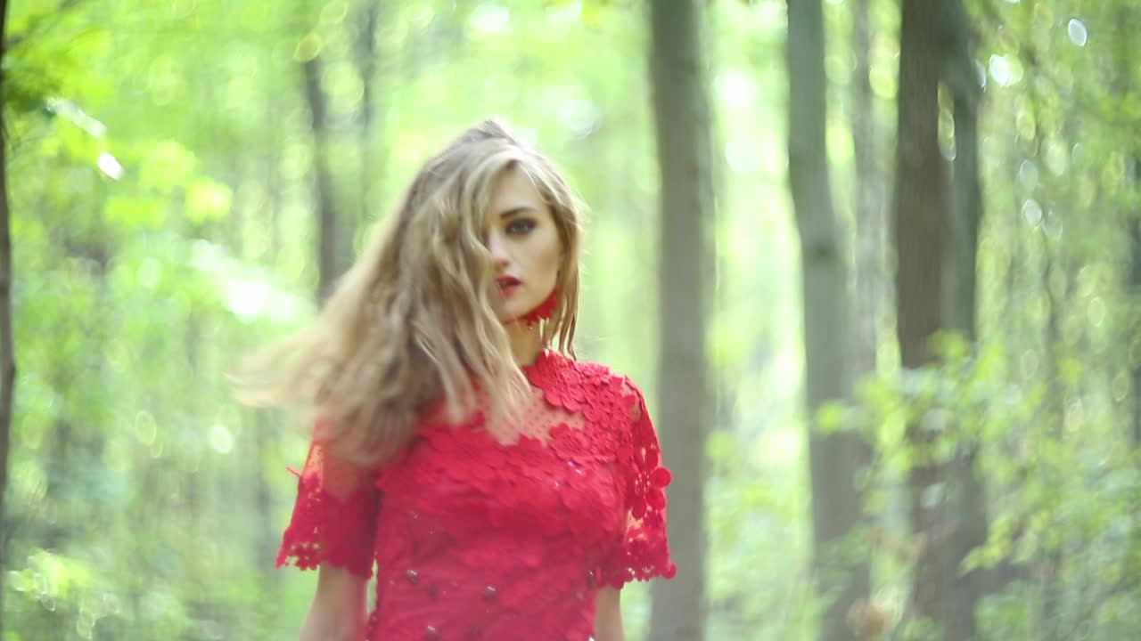 Pretty Woman Walking In The Forest. Pretty woman in a long red dress walking in the forest