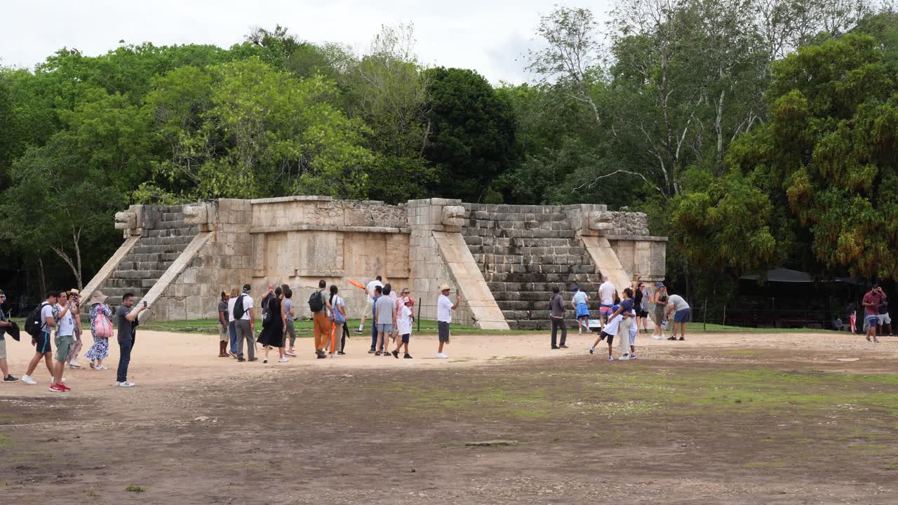 Tourists visiting Venus Platform (Plataforma de Venus) at Chichen Itza mayan archaeological site.