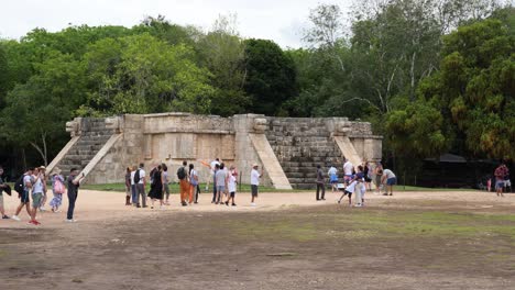 tourists visiting venus platform (plataforma de venus) at chichen itza mayan archaeological site.