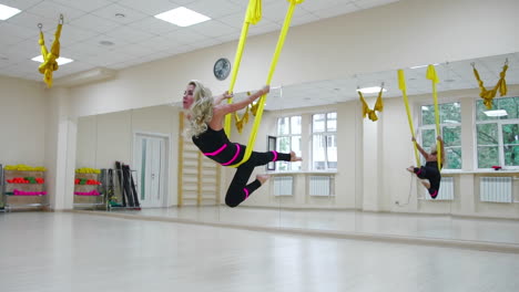 el concepto de deportes para un estilo de vida saludable. chica dedicada al aero yoga en el lienzo balanceándose y estirando los músculos