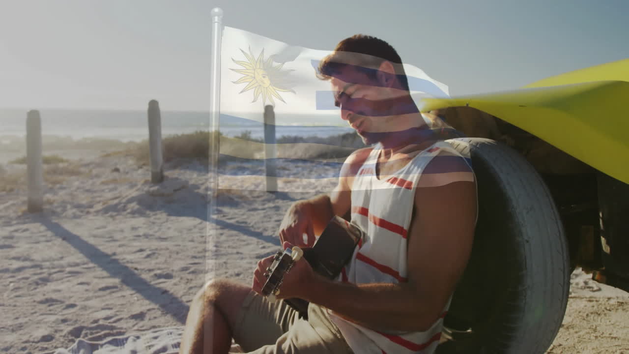 Playing guitar on beach, man with Uruguay flag animation in sunlight