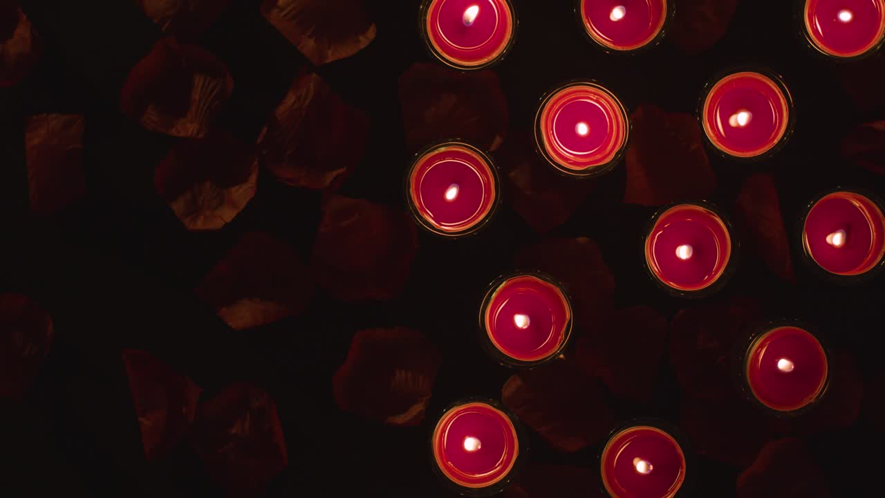 Overhead Shot Of Romantic Lit Red Candles On Background Covered In Rose Petals With Copy Space 1