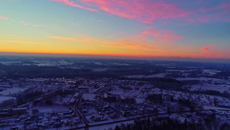 gradient colorful sunset pink blue skyline above frozen city winter town location houses below white freezing village, establishing shot