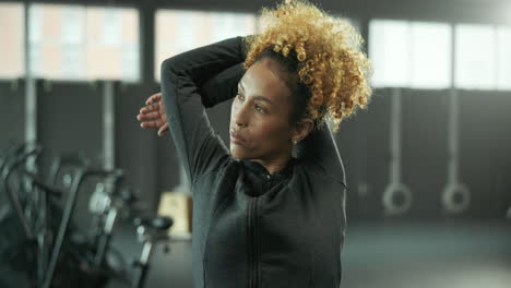 mujer estirándose en el gimnasio
