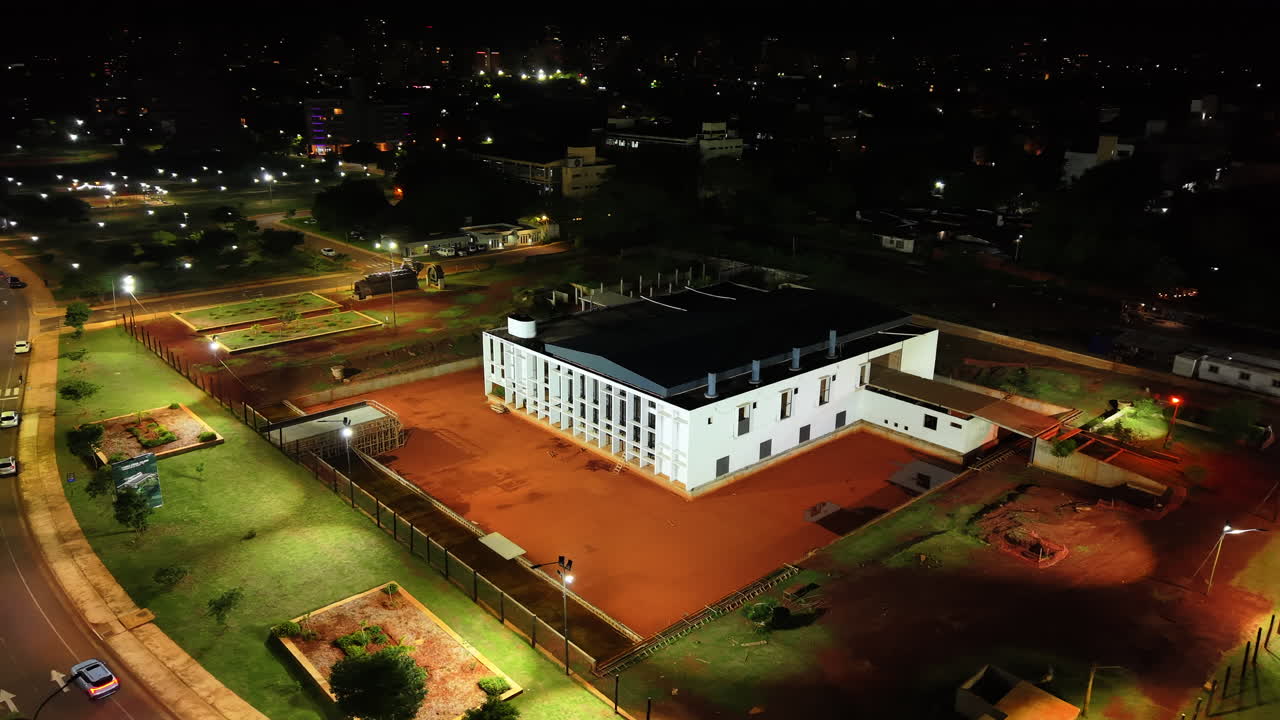 Brightly lit iconic Museo del Conocimiento building at night in the center of Posadas city, Misiones, Argentina.