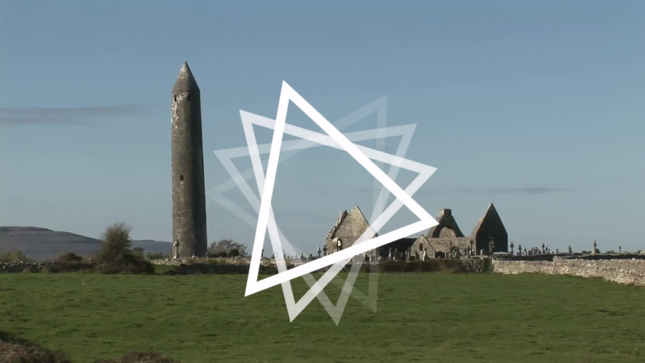 White triangle animation over ancient stone buildings and round tower in countryside