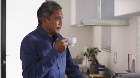 Älterer-Mann-Gemischter-Abstammung-In-Der-Küche,-Der-Kaffee-Trinkt