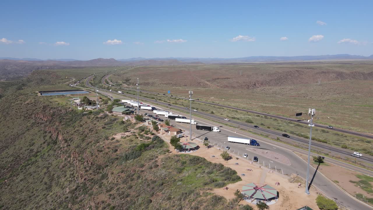 drone acercándose hacia una parada de descanso al costado de la autopista en arizona, semis, baños, marquesinas, torres celulares