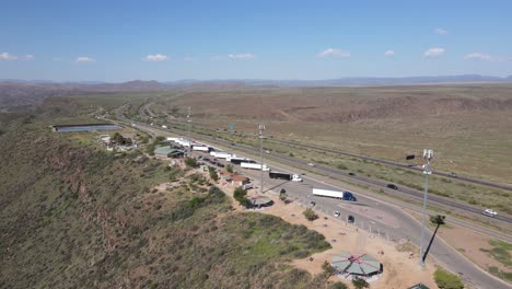 drone acercándose hacia una parada de descanso al costado de la autopista en arizona, semis, baños, marquesinas, torres celulares
