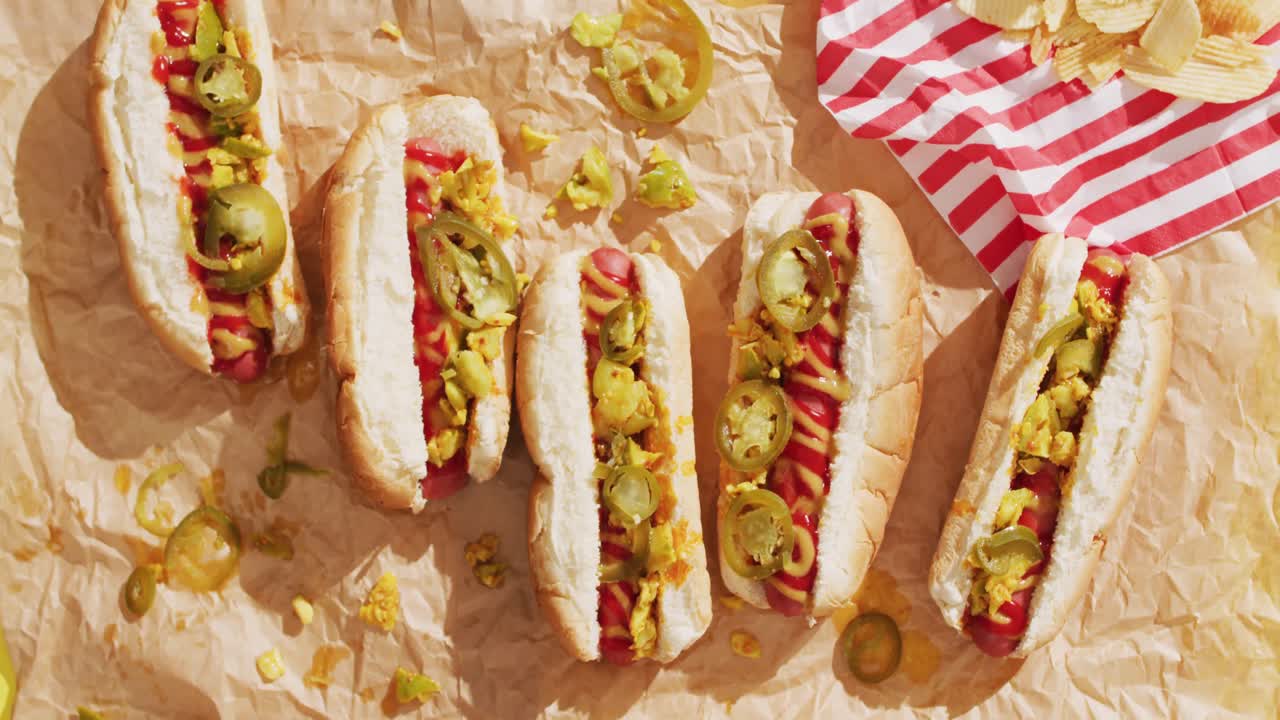 노란색 표면에 겨자, 케 ⁇  및 jalapeno와 함께 핫도그의 비디오