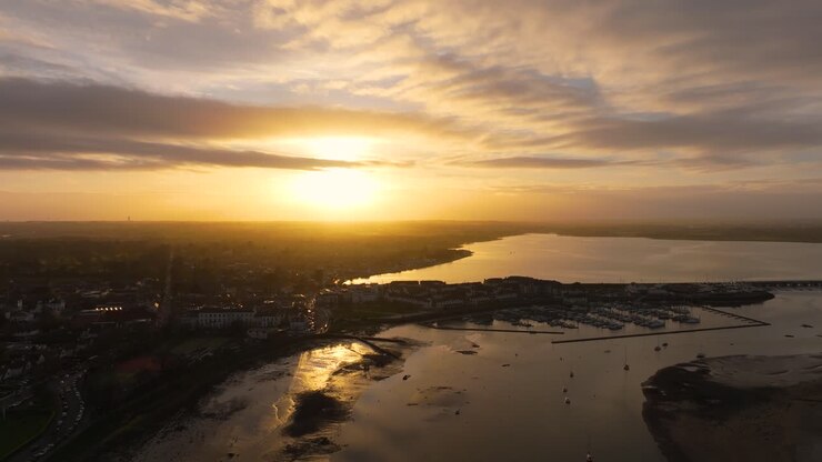 Filmagem de drone cinematográfica em 4K capturando a praia de Malahide, durante a hora dourada, com pôr do sol quente em Co.Dublin - Irlanda_1o