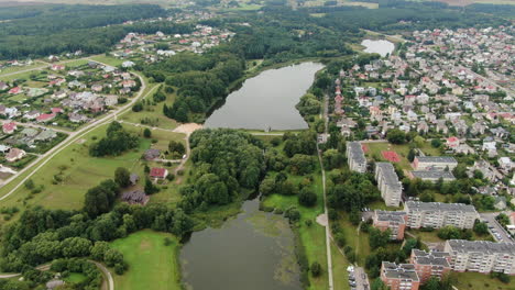 central park of jonava with small water dam and living district, aerial drone view