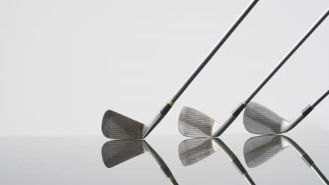 close up of golf clubs on white background, copy space, slow motion
