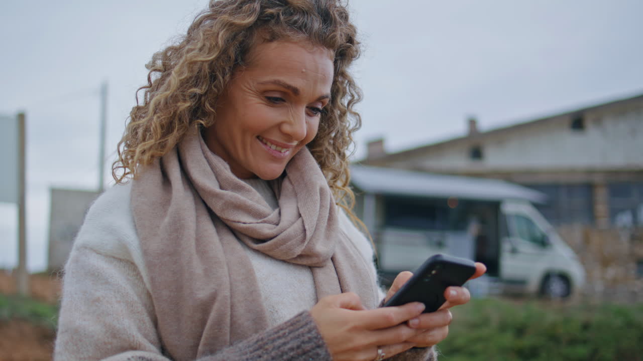 Woman shooting travel blog on cellphone standing camping place close up.