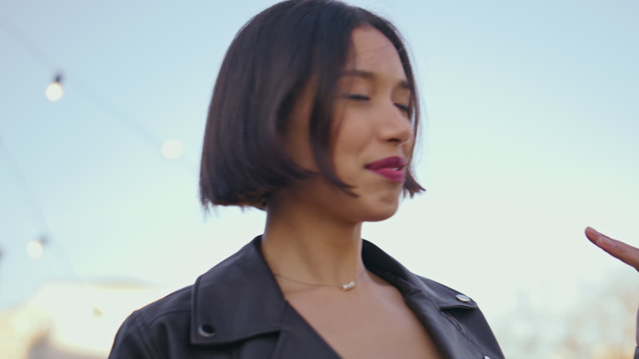 클로즈업 아시아 소녀가 음료 테라스 디스코와 함께 춤을 추고 있습니다. 젊은 여성이 파티를 즐기고 있습니다.