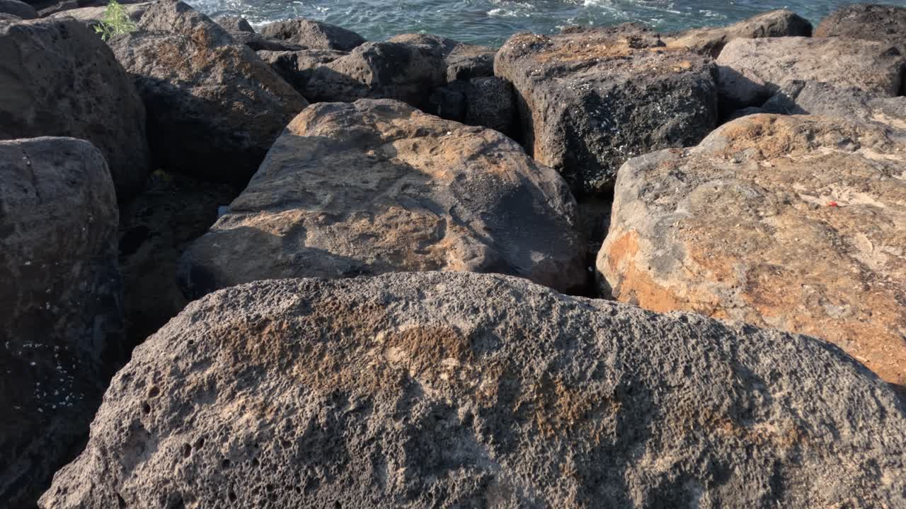 Waves hitting rocks near a pier