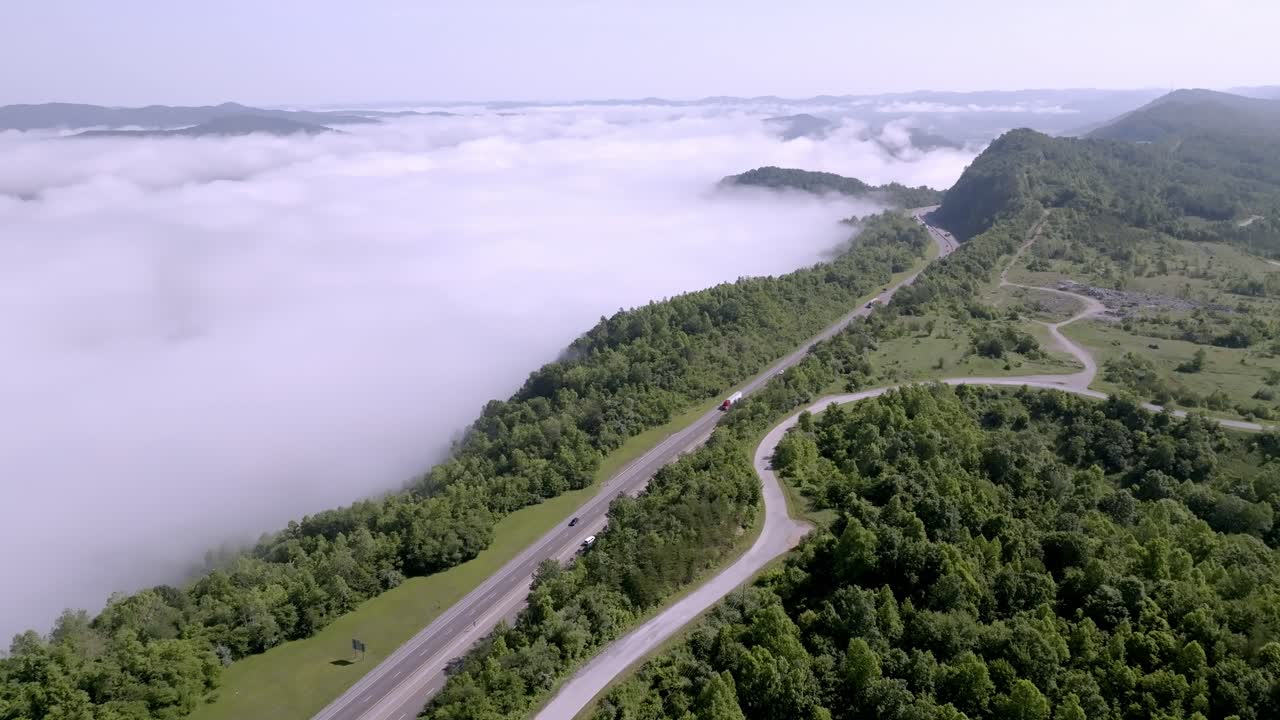 nubes y niebla junto con el tráfico en la interestatal 75 cerca de jellico, tennessee en las montañas de cumberland con drones video estable vista amplia