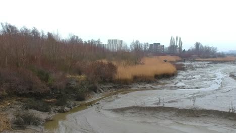 empuje en la antena lecho seco del río charco fangoso hierba de trigo alto brumoso día nublado