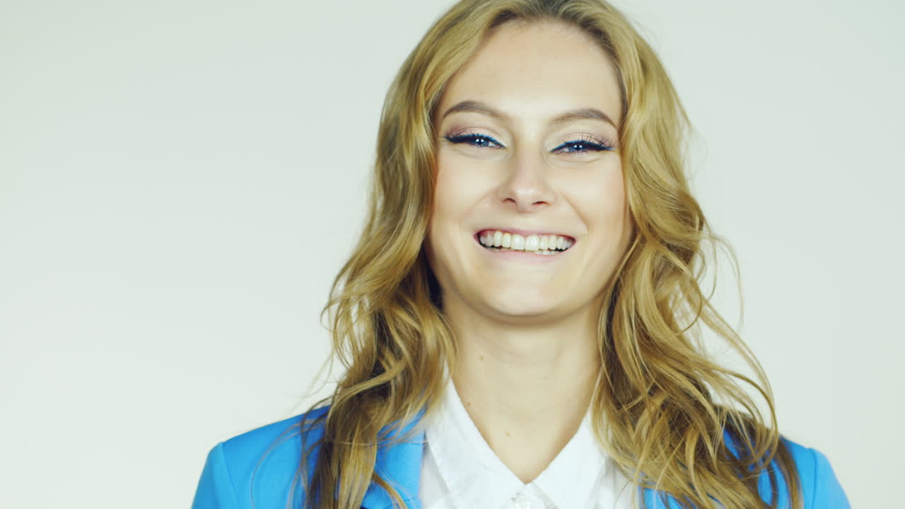 retrato de una mujer de negocios que sonríe alegremente a la cámara filmada en el estudio sobre un backgr blanco