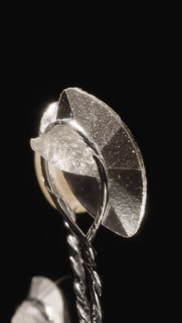 elegant hairpin with shiny gemstones at bright studio light. glamorous silver accessory designed for female hairstyles on black background macro