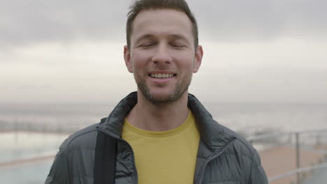 close up portrait of handsome man smiling cheerful on cloudy seaside