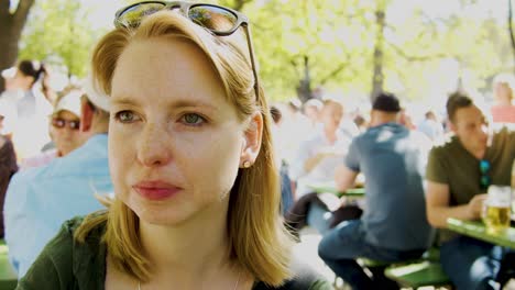 Woman-drinks-from-glass-in-a-crowded-place