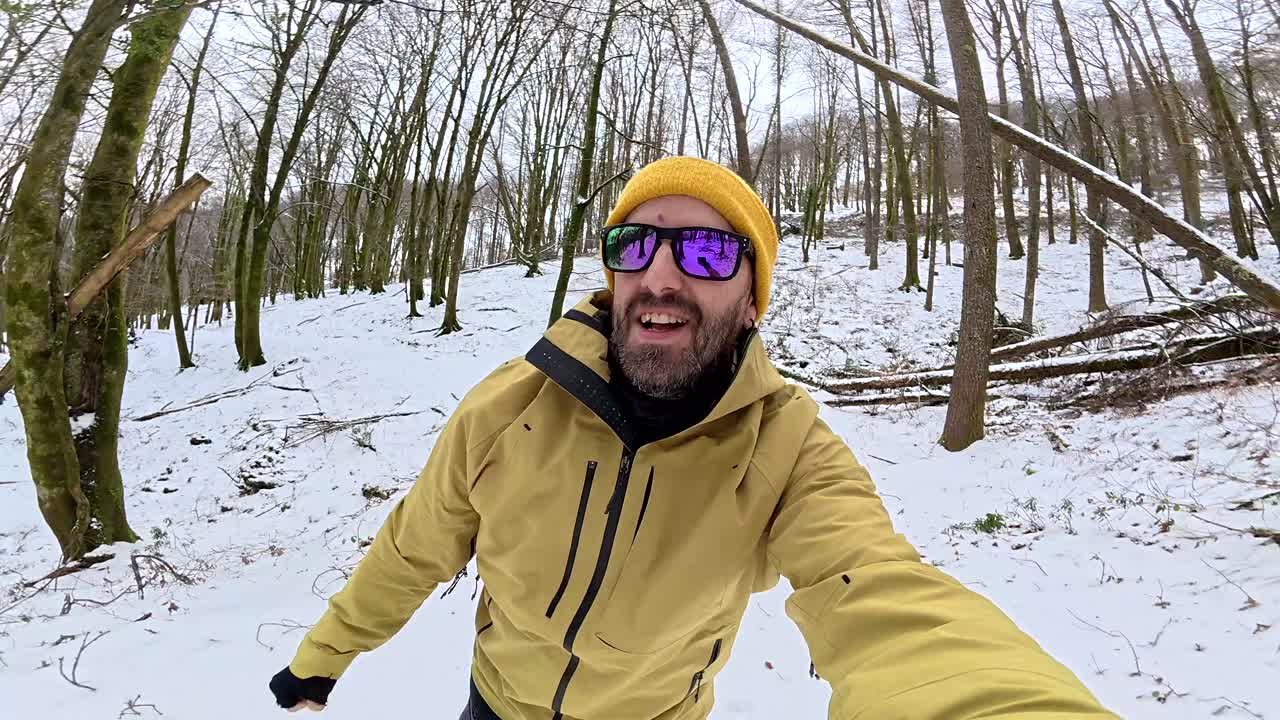 Uomo che si scatta un selfie in una foresta innevata