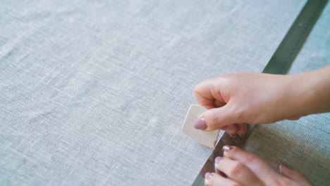 seamstress-makes-marks-on-linen-fabric-with-chalk-and-ruler