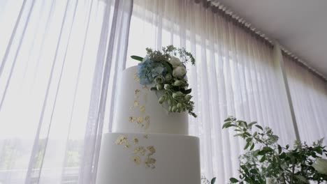 elegant tiered wedding cake adorned with flowers and gold accents