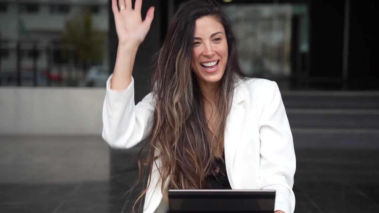Una giovane donna intenta con il suo tablet in un vivace ambiente urbano che rappresenta la vita moderna.