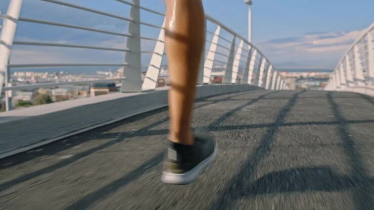 Close-up of Athlete Running on Pedestrian Bridge