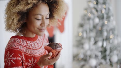 mujer joven saboreando un pastel de navidad