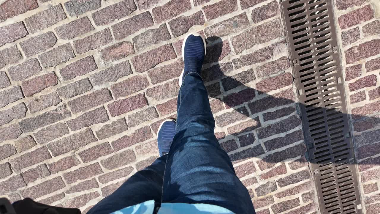 persona que camina por el pavimento de adoquines