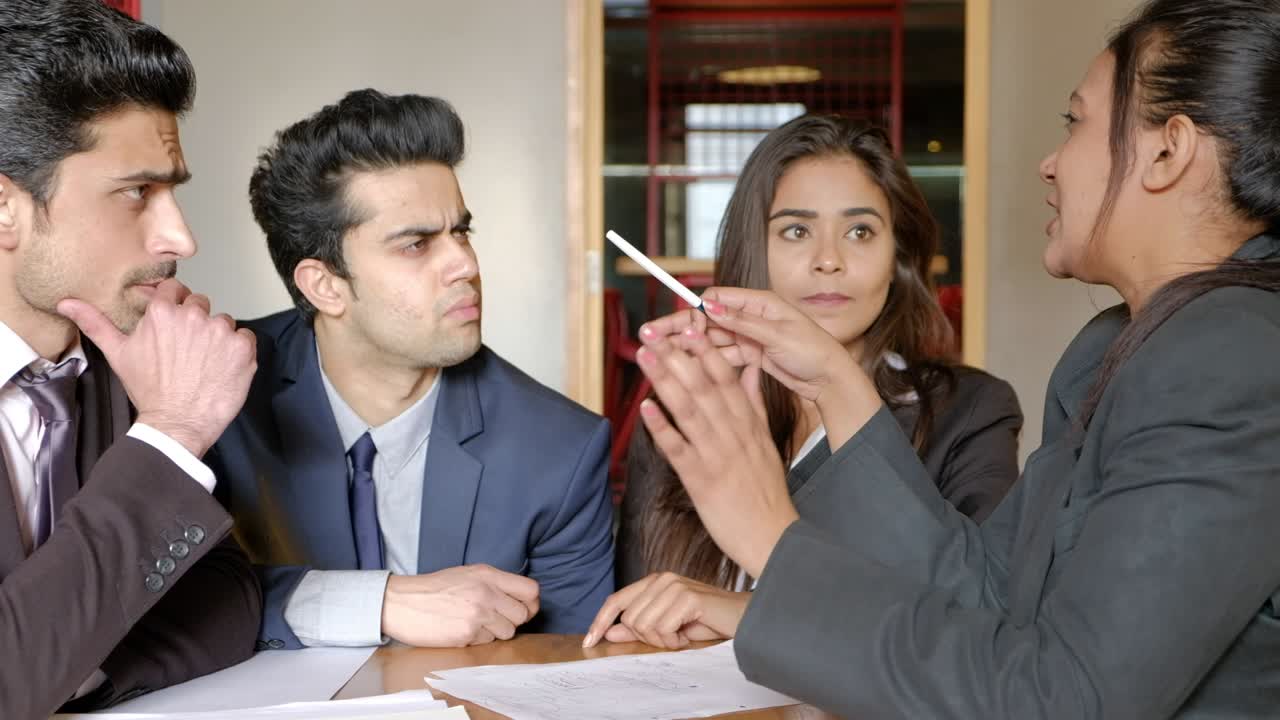 Serious business meeting with the team leader giving her instructions for her team to follow as they listen with intent carefully and nod their heads