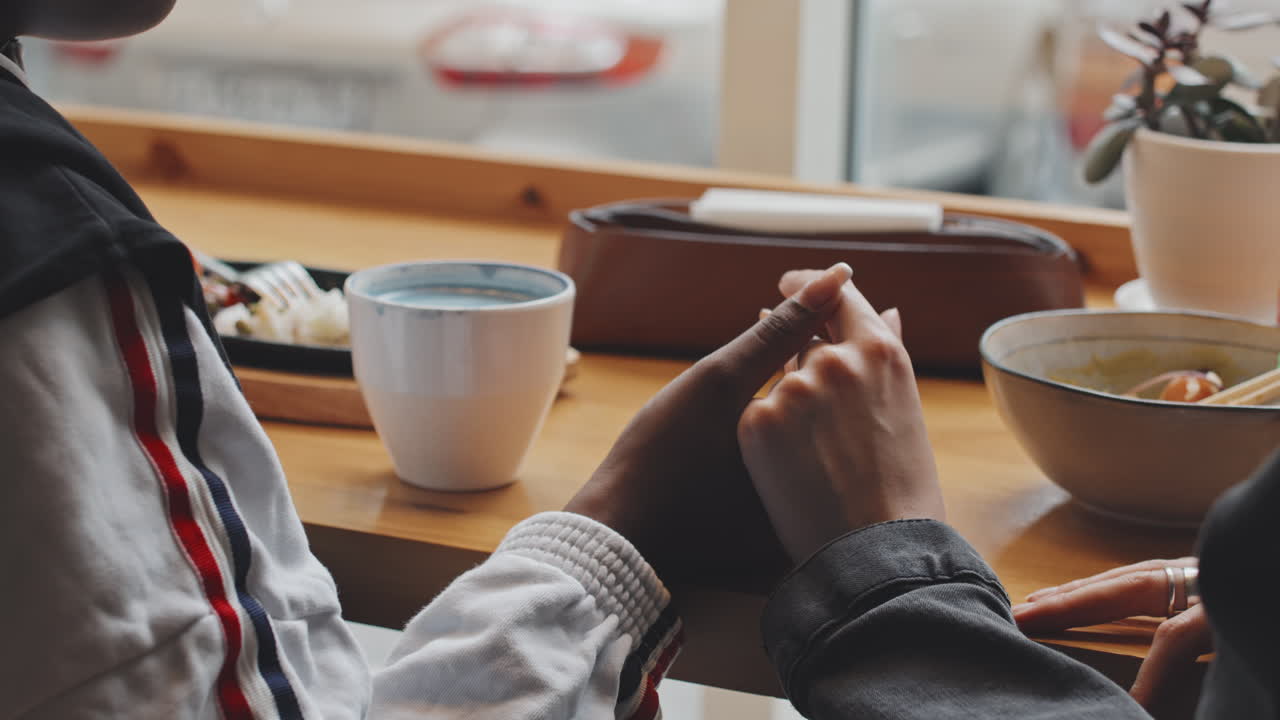 Female Couple Holding Hands in Cafe