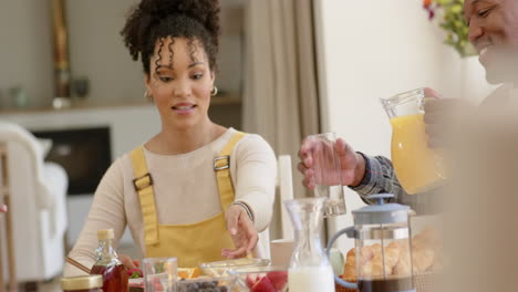 happy african american parents and daughter having breakfast at home, slow motion