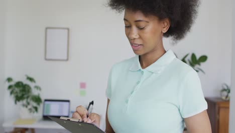 portrait of happy african american female physiotherapist at home