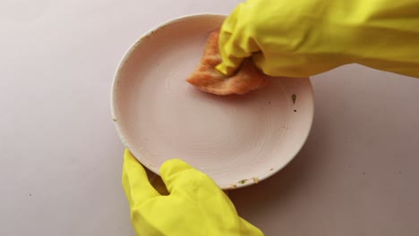 sponge , rubber gloves and ful plate on blue