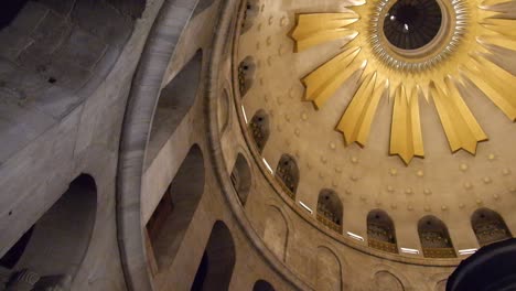 view looking up at the ornate dome ceiling above jesus christ's empty tomb in the church of holy sepulchre in jerusalem