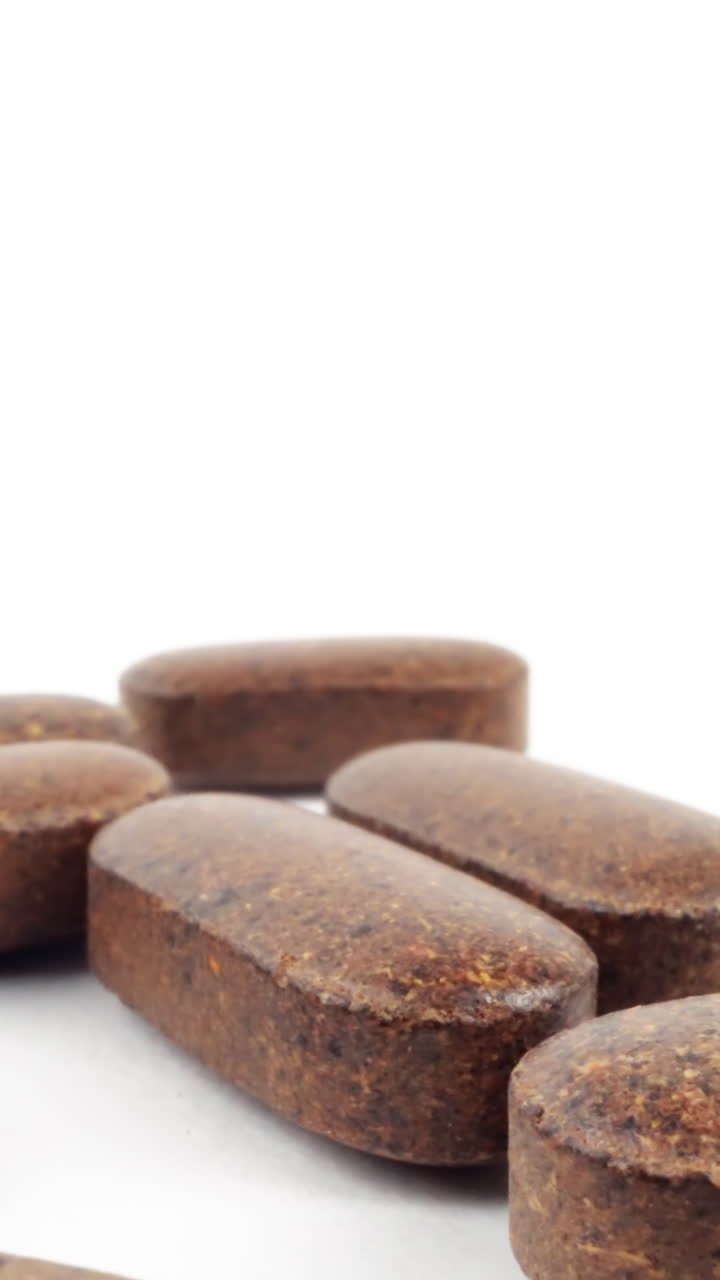 disparo de alta clave de pastillas de hierbas marrones en un fondo blanco puro con sombras suaves