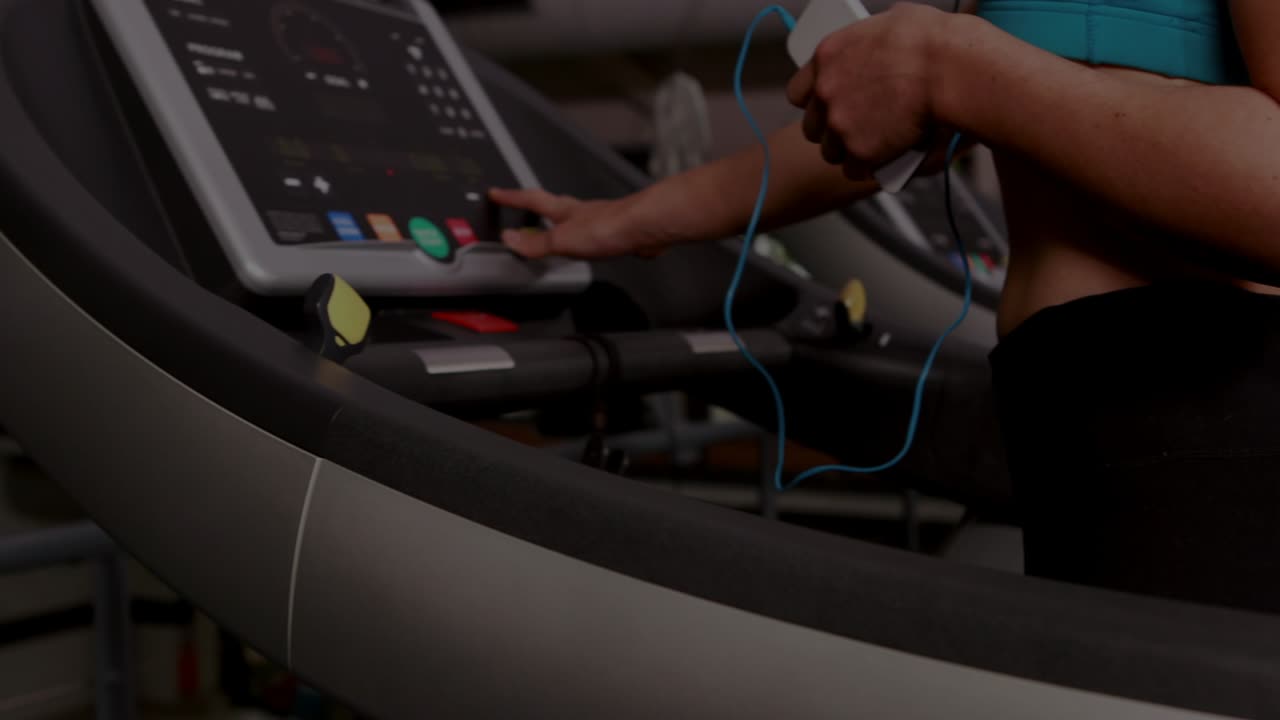 Adult female gym user tapping treadmill console, adjusting speed, starting workout, HUD overlaying