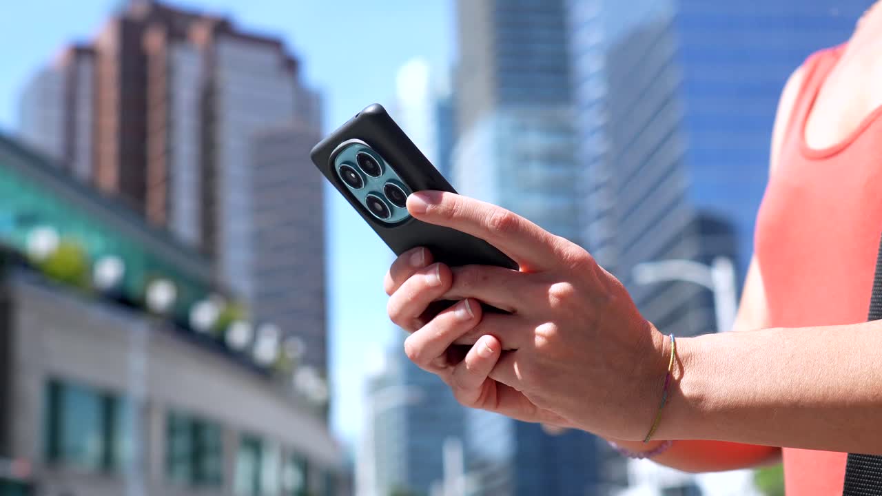 Persona che usa un telefono cellulare in città