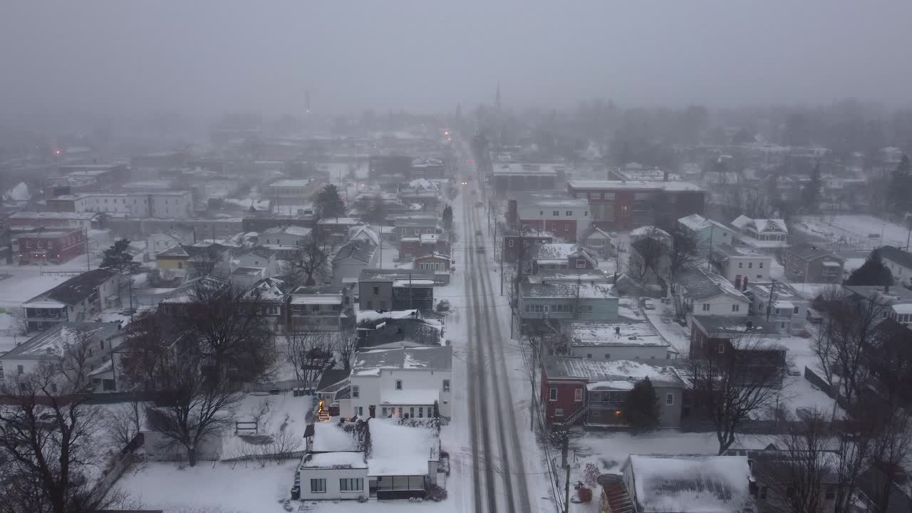 vehicles driving through Orford after experiencing a heavy blizzard in winter