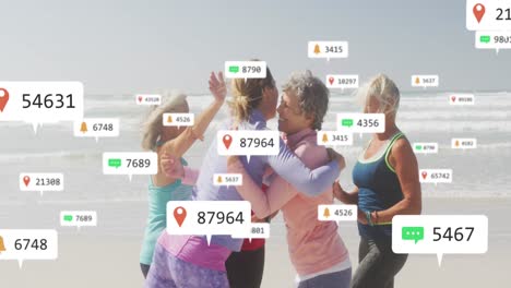 Animation-of-social-media-notifications,-over-women-exercising-embracing-on-beach