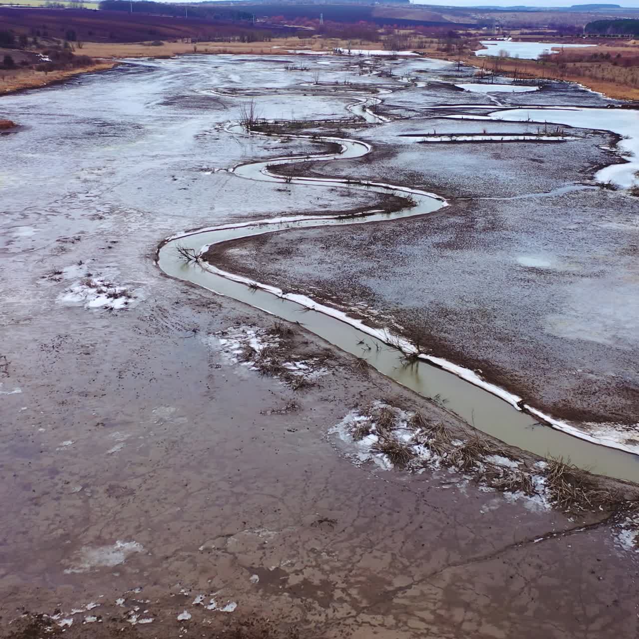 Dried lake. Ecological disaster in environment. Global warming. Tortuous river on dirty background. Motion camera back. Aerial view
