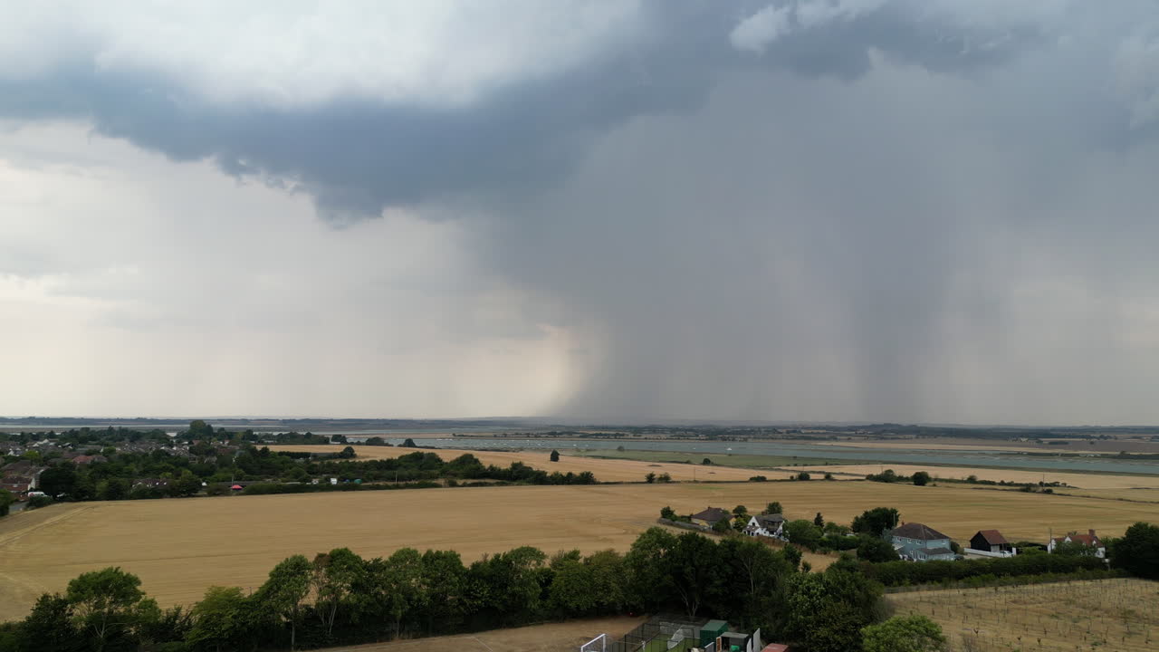 건조한 여름 들판의 항공 영상, 멀리 떨어진 곳에 큰 폭풍 셀이 있고, 비가 내리고, 드론 전진 동작
