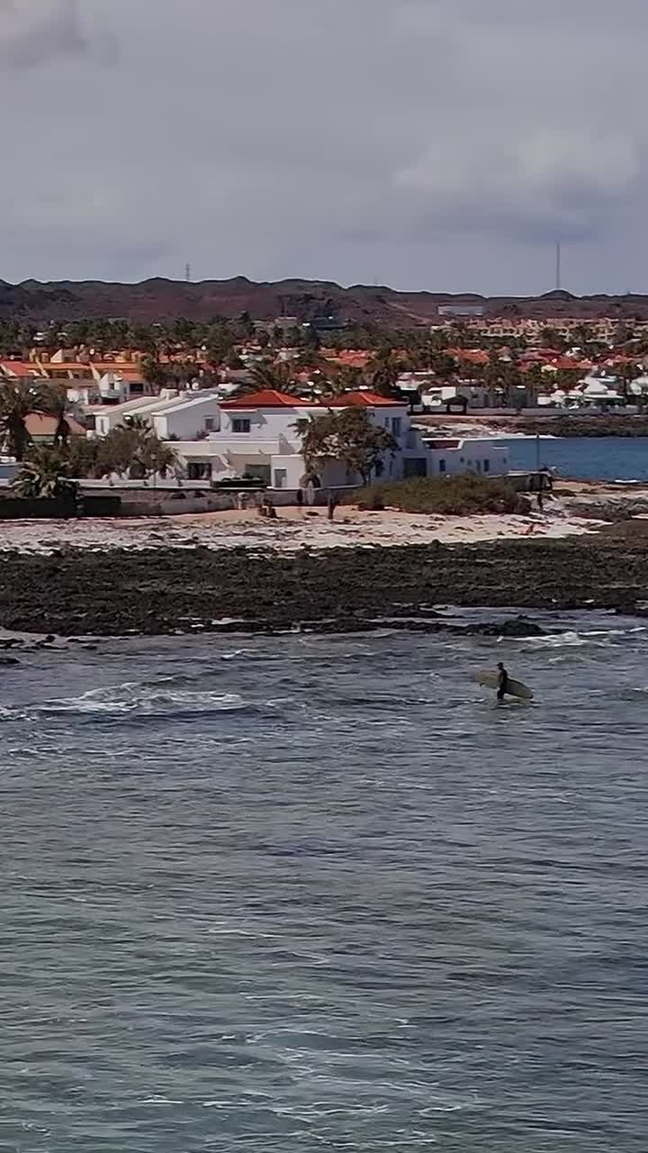 Surfer rir på bølger nær kysten av Kanariøyene i Spania