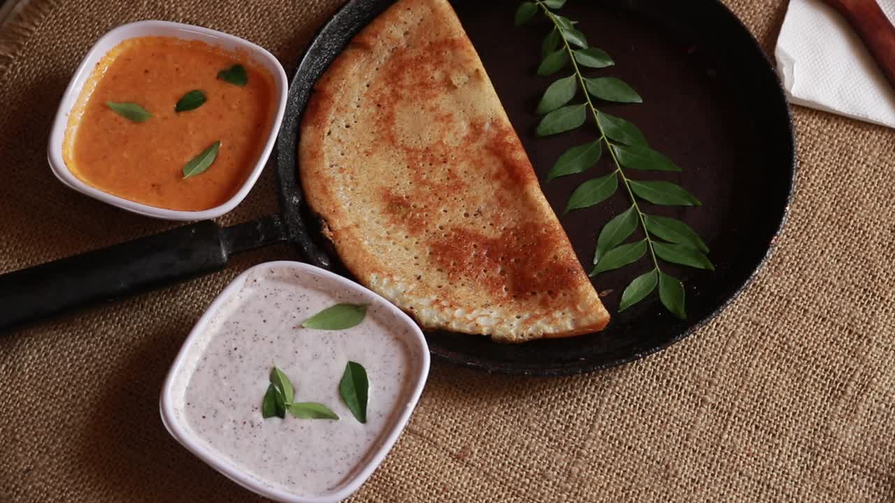masala dosa giratoria - crepes salados indios con relleno de patata, vista de arriba hacia abajo sobre fondo de madera