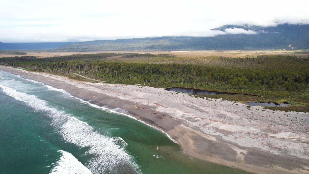 Scenic Sandy Beach With Forested Coastline On Bruce Bay, South Island, New Zealand. aerial pullback ascend
